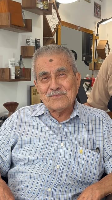 Cliente sonriendo en el sillón de Waldorf Barber Studio