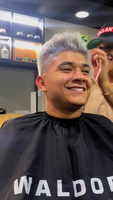 Cliente con decoloración platinada y capa de Waldorf Barber Studio